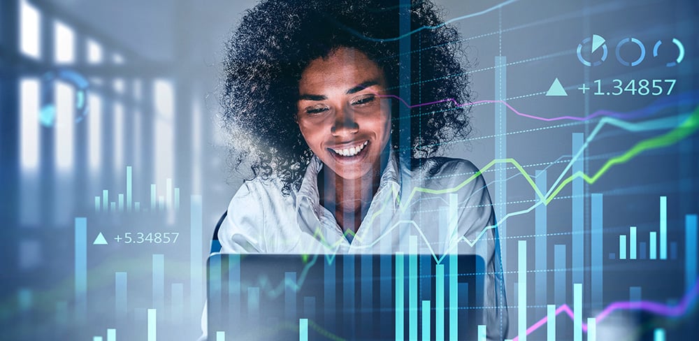 Smiling African woman at computer overlaid with fintech data - for careers in FinTech representation